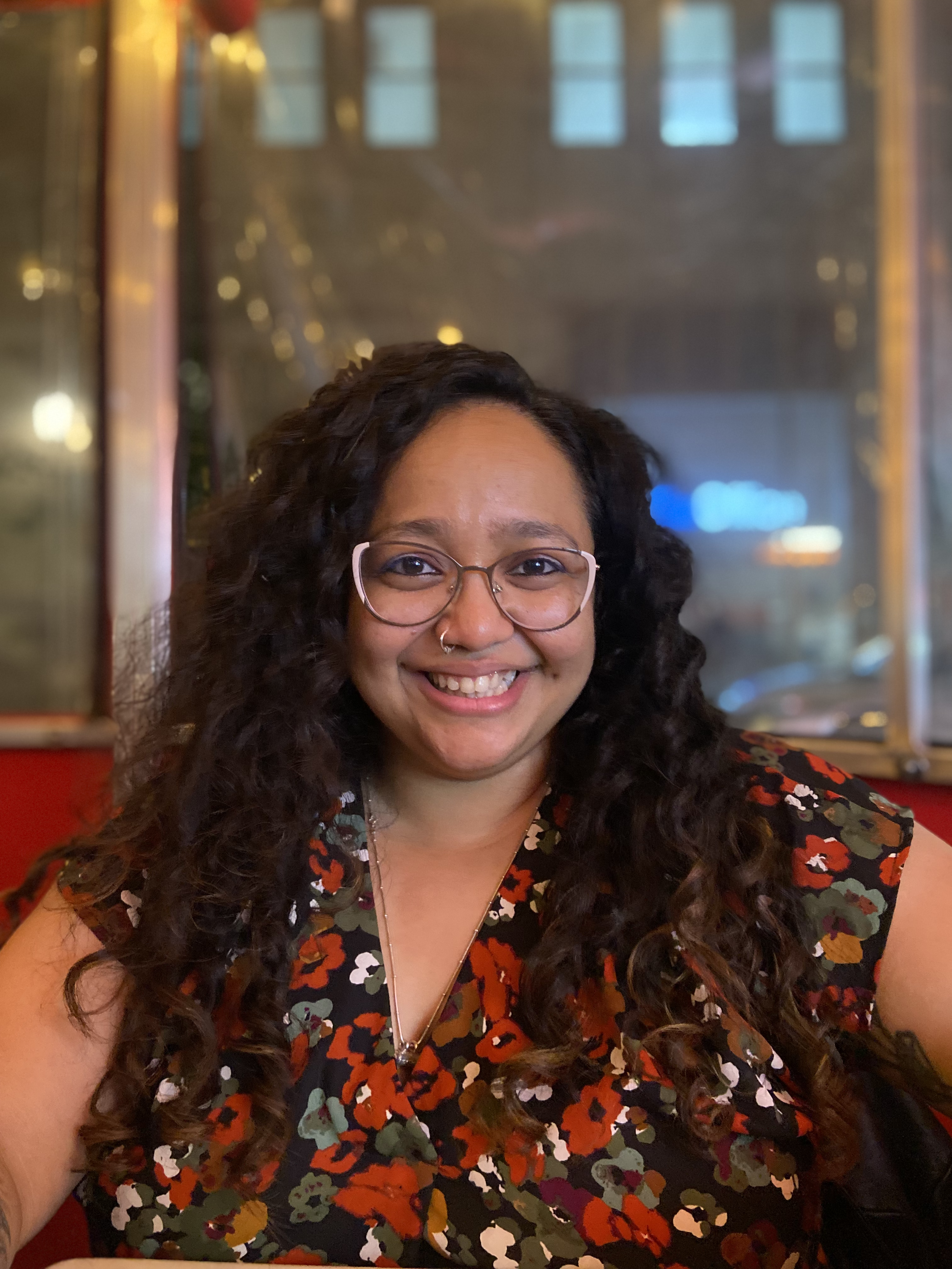 A photo headshot of a smiling Neha (Writing Fellow).