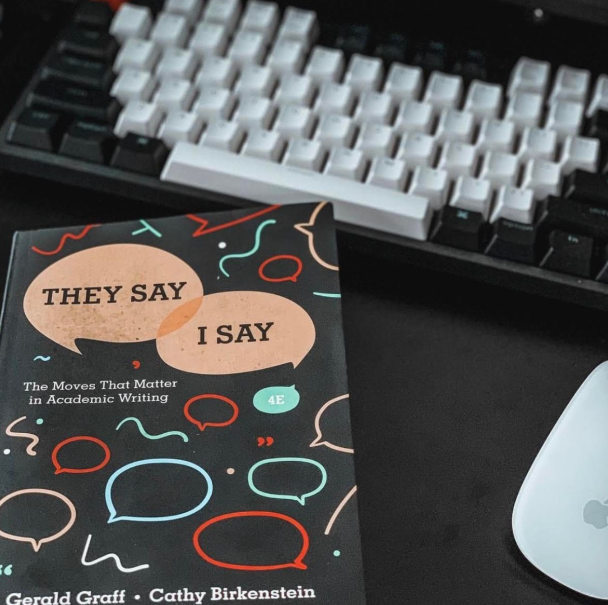 A book on academic writing resting on a desk below a keyboard