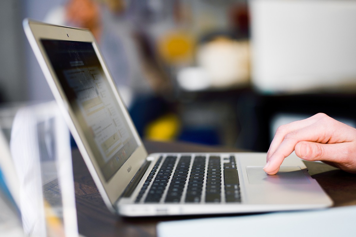 hand using a laptop, side view