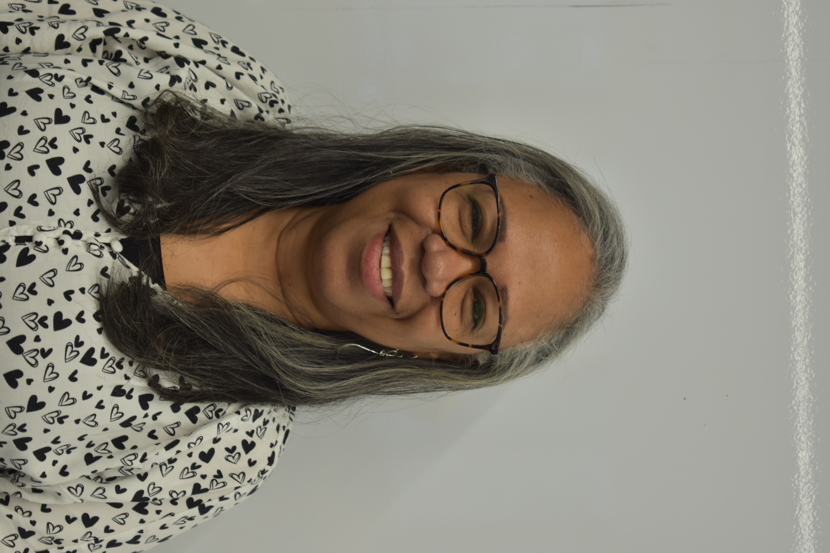 A person smiling against a white backdrop.