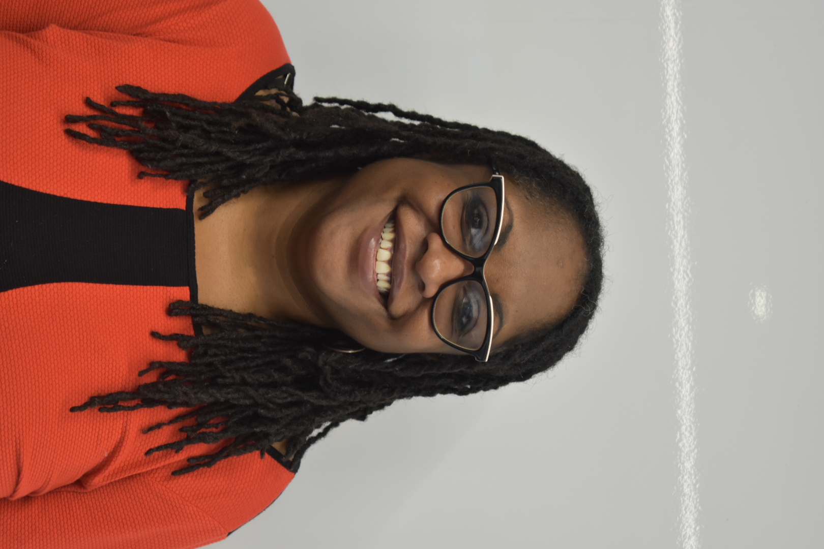 A person smiling against a white backdrop.