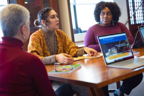 Group of three Ph.D. in Leadership program students discussing course content around a table at Teachers College