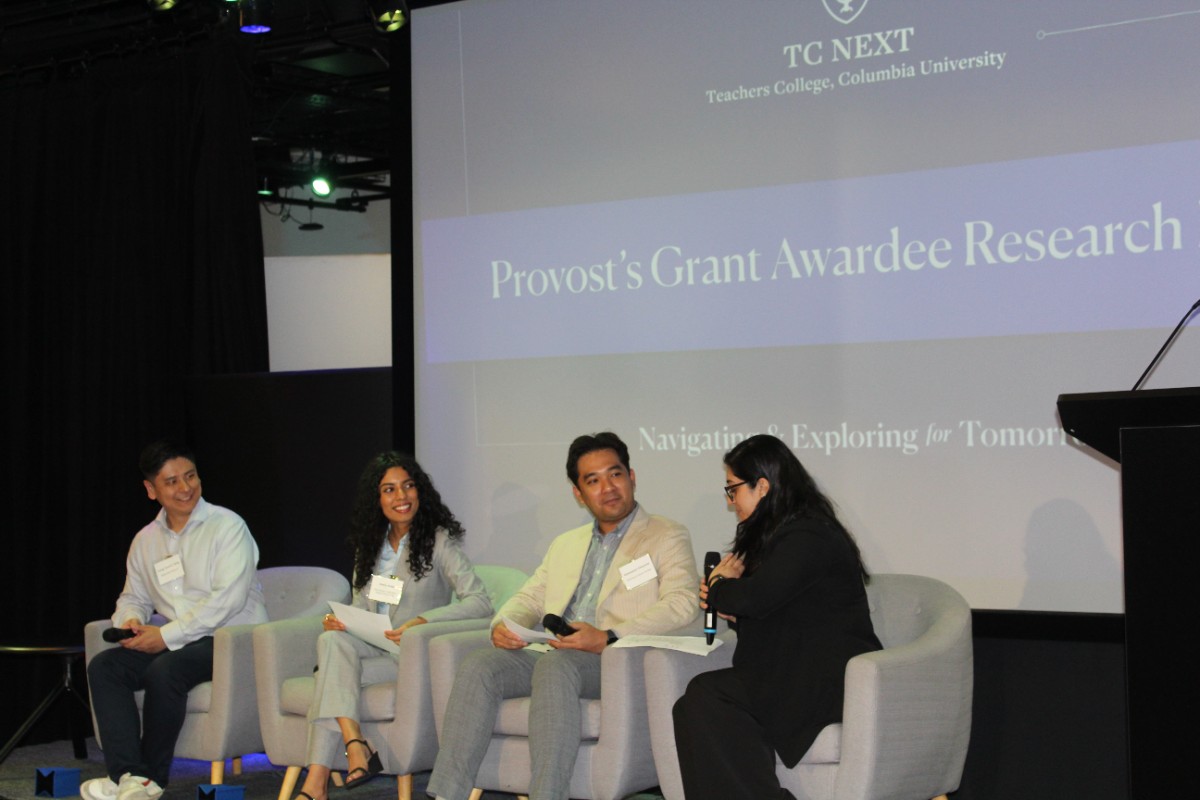 3 students on a panel with the Dir of TC NEXT in front of PG Awardee Research Expo sign