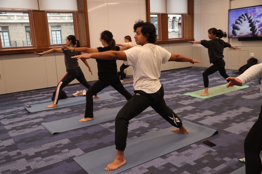 Group of people participating in a yoga class in a TC classroom