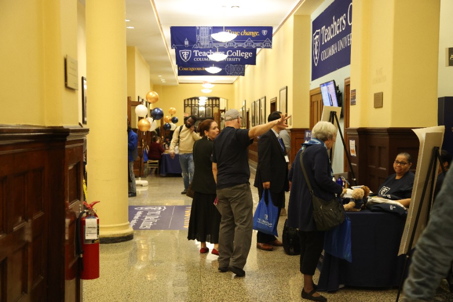 A busy hallway with people gathered near the event registration desk