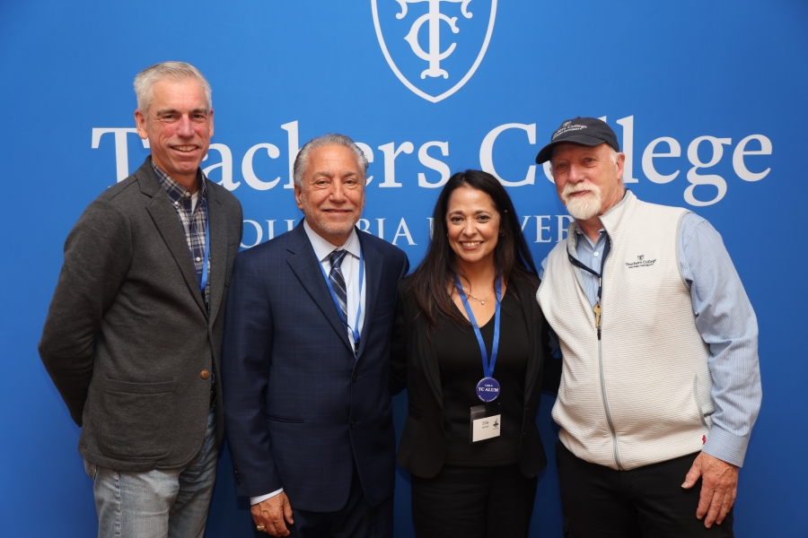 Four people standing and smiling at a TC Alumni Day 2024 event