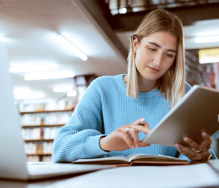 Woman looking at tablet in library