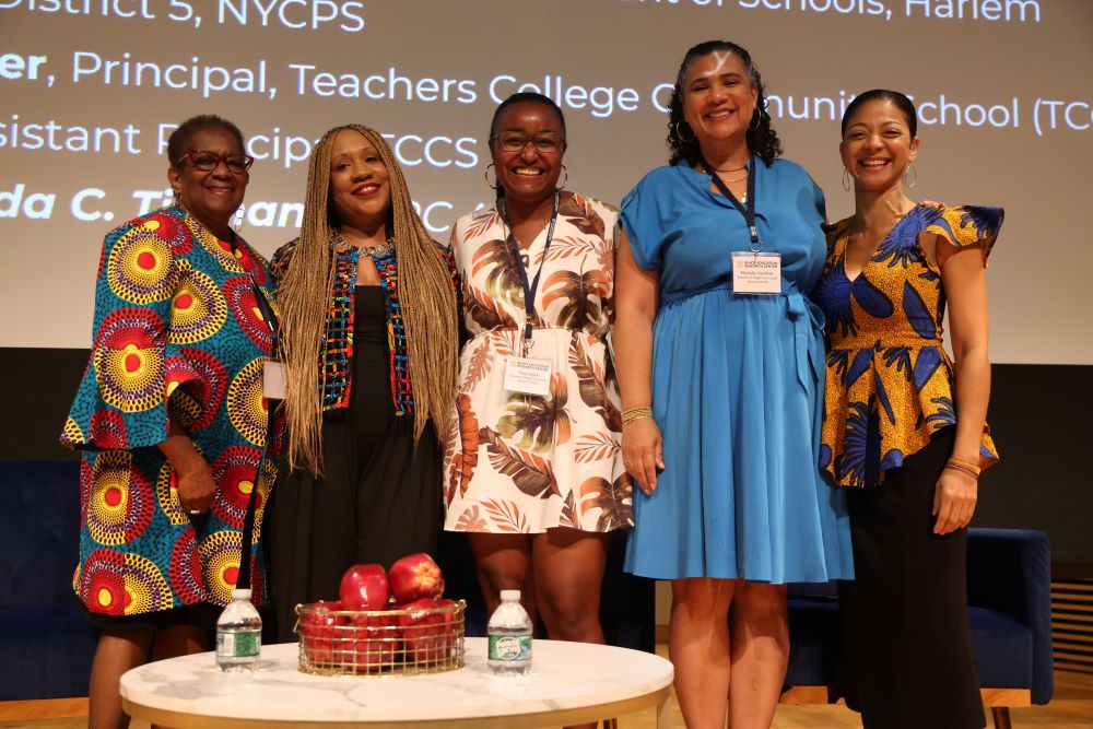 Five women standing and smiling on stage at a BERC event