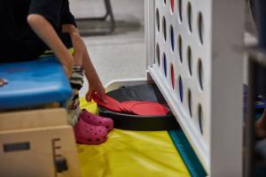 A child picks up large discs to play Connect Four