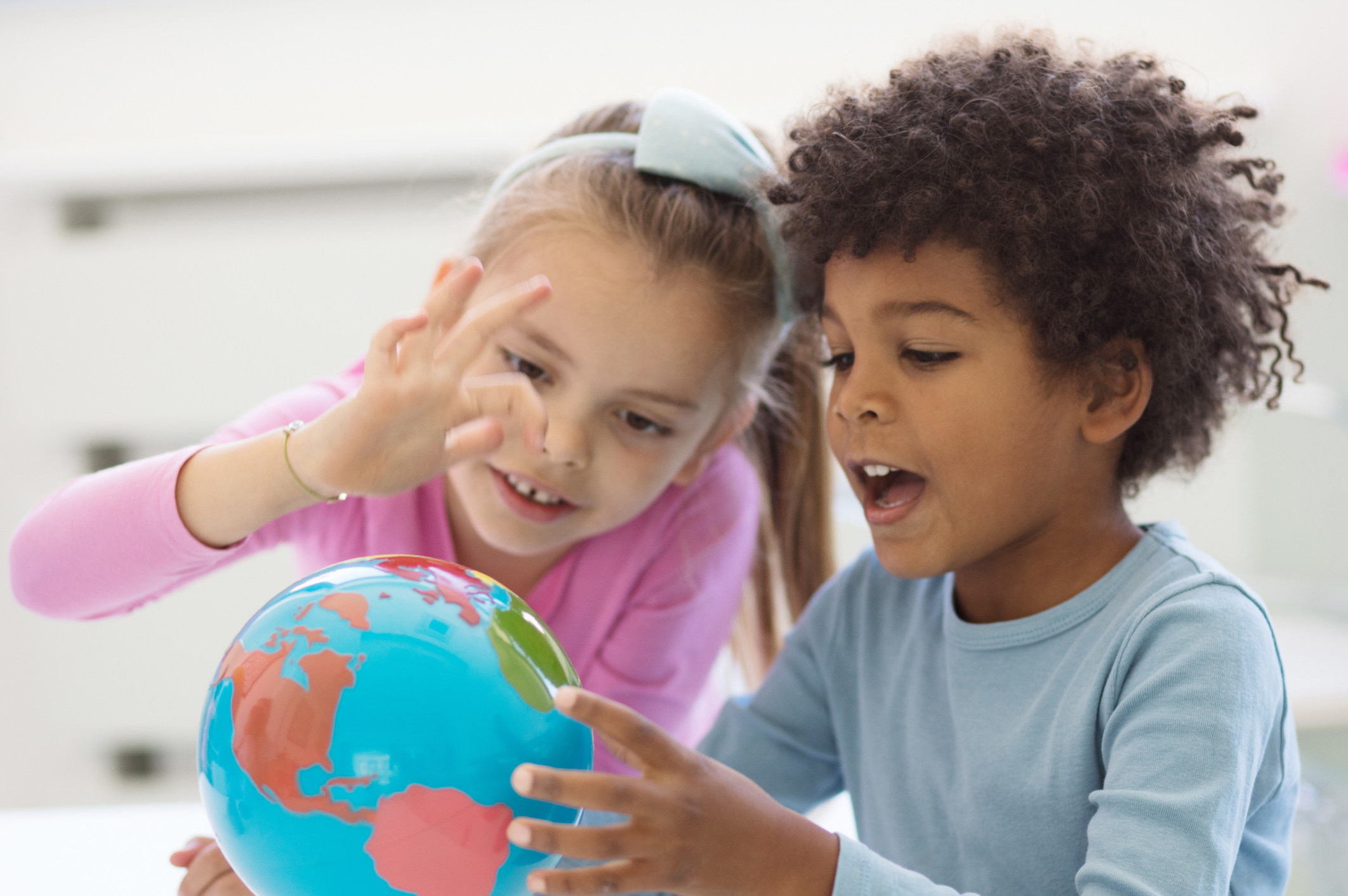 Young kids looking at globe