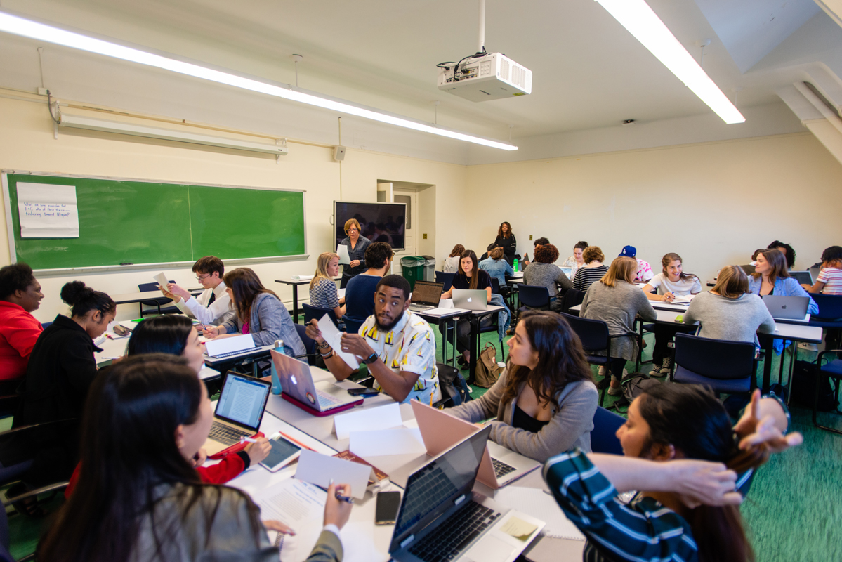 Students have discussions around their laptops in an EPSA Classroom