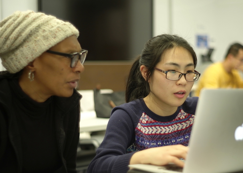 two learning analytics students reviewing items on computer