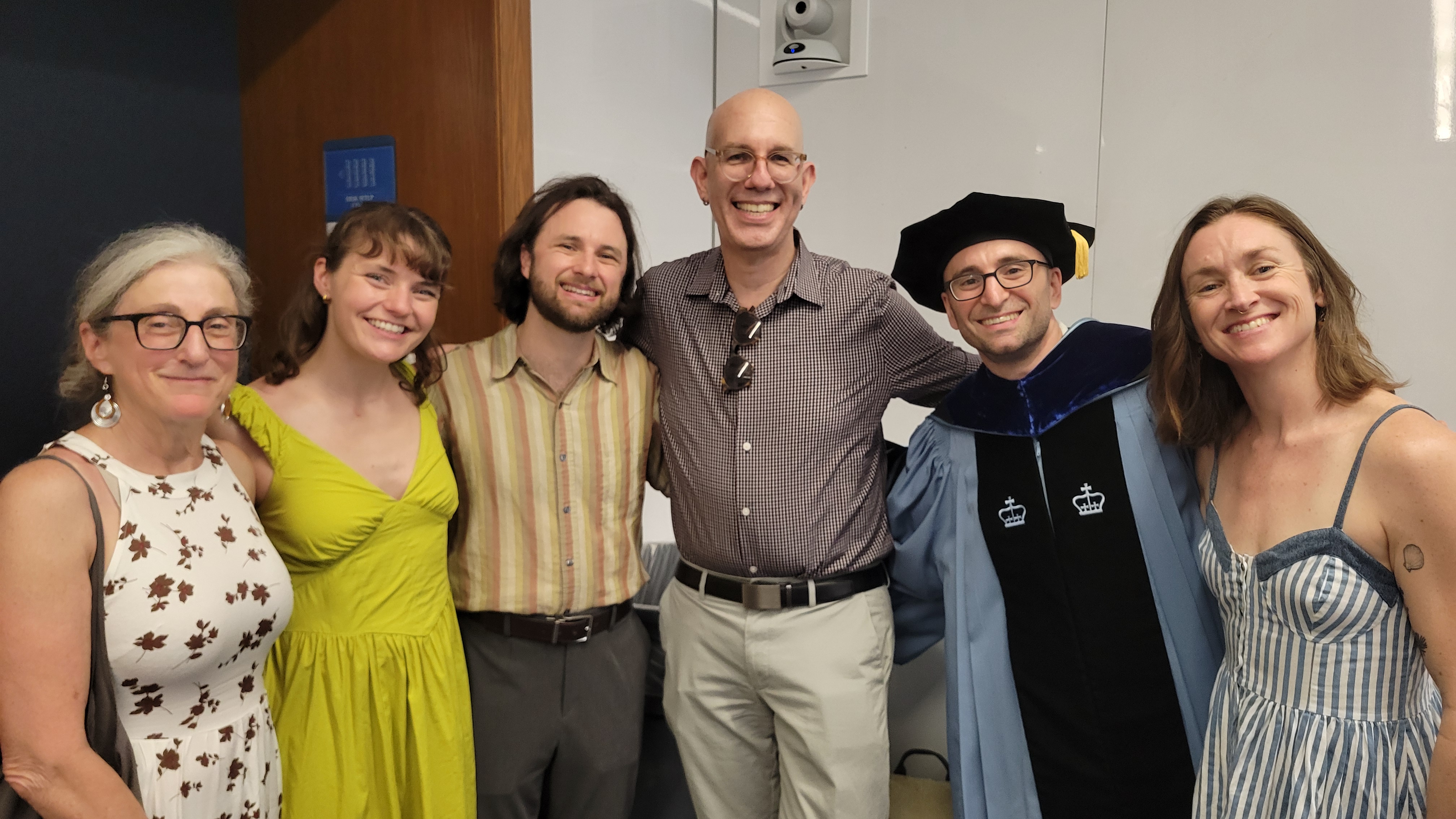 A graduate with family and advisor