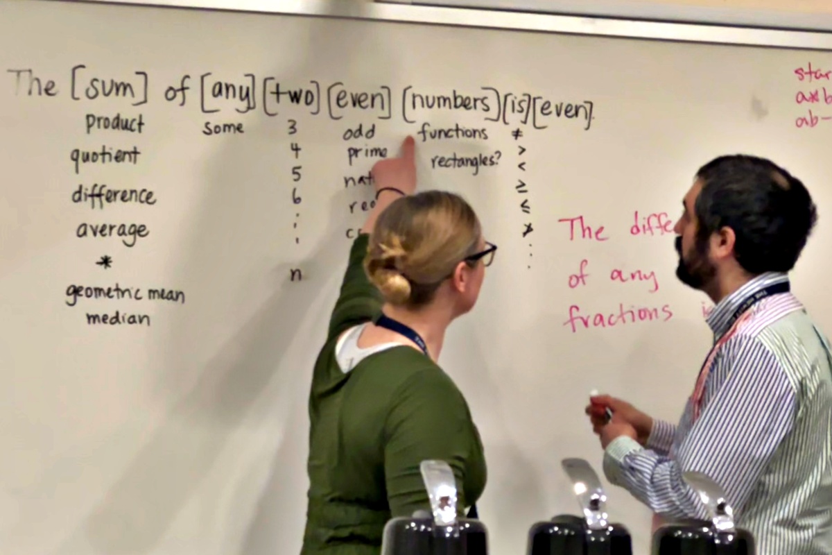 two teachers at a white board