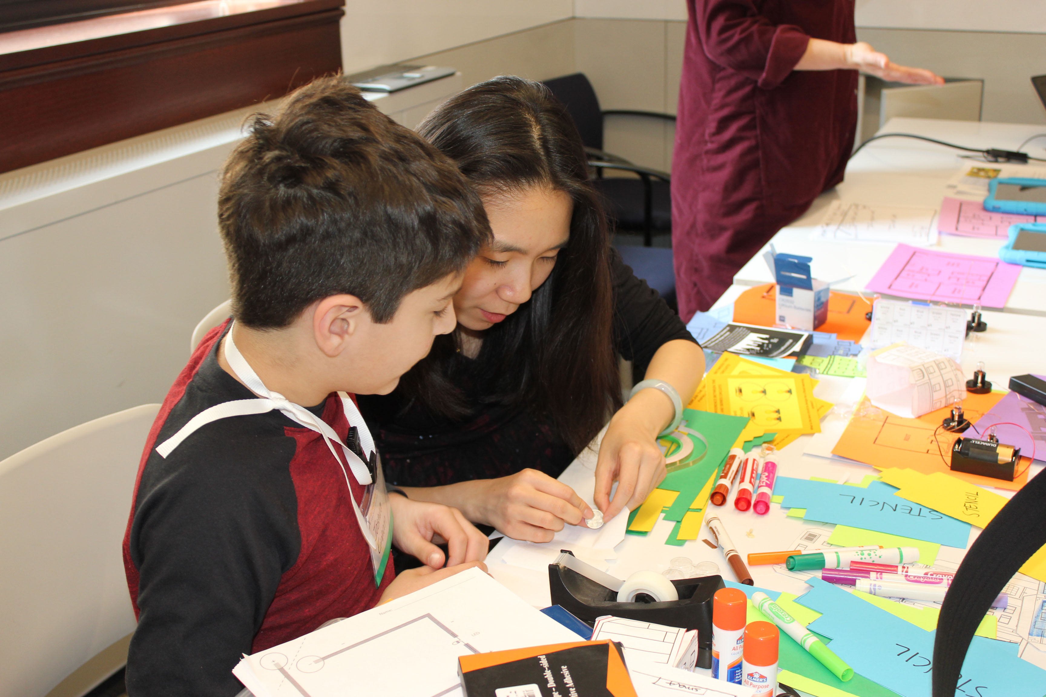 Graduate student shows young student a demo