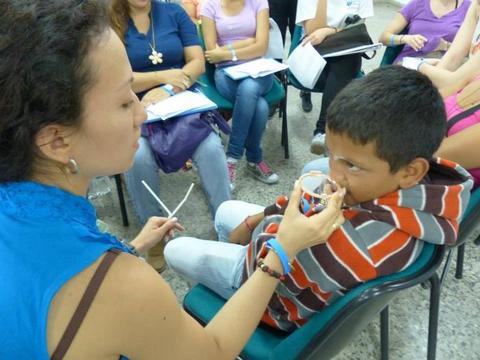 Therapist working with boy using mirror.