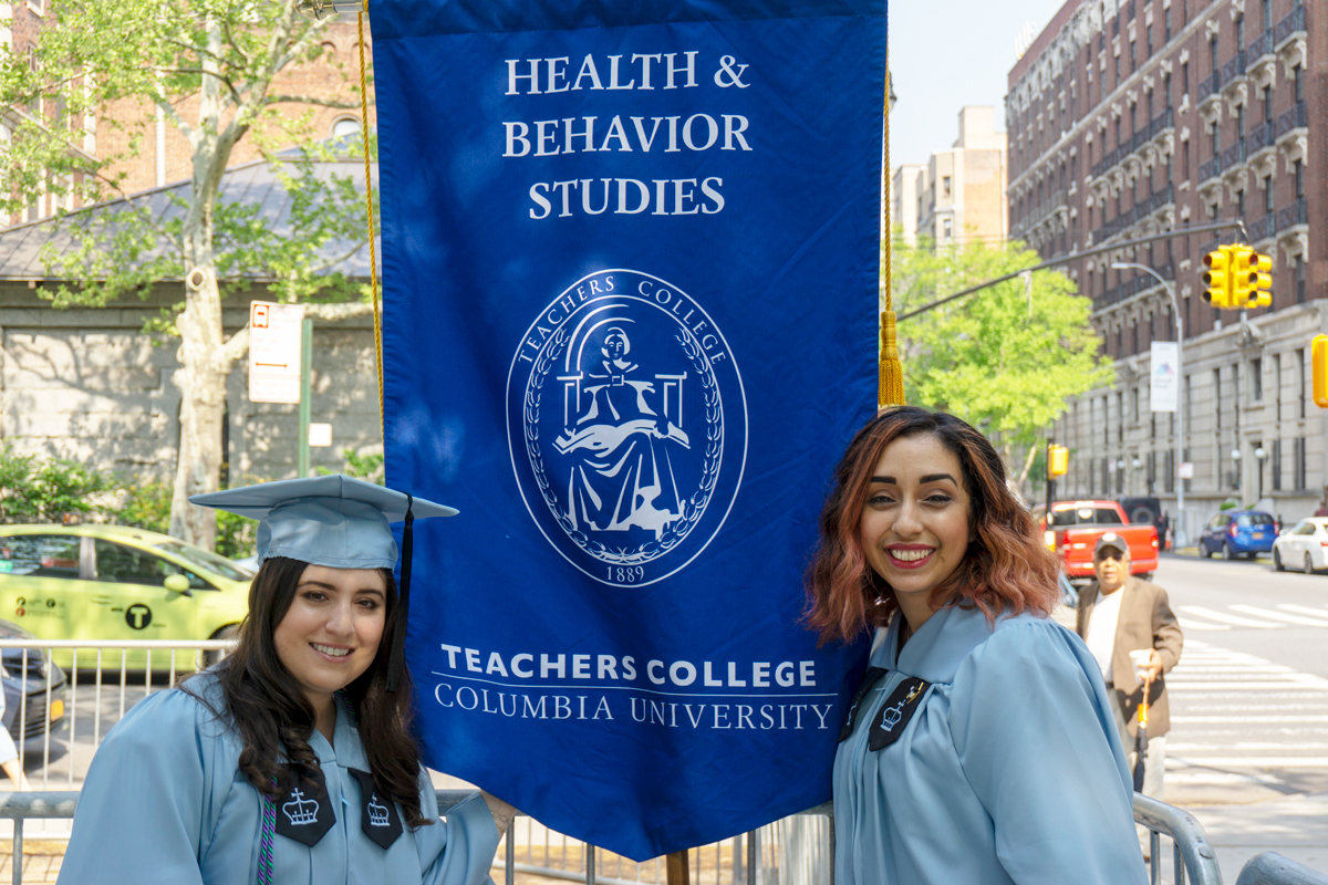 Two students with a flag that says 