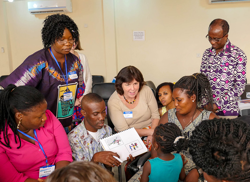 HOUSE CALL Professor Cate Crowley (center, in white) and students from TC's Program in Communication Sciences & Disorders conduct speech therapy for cleft palate patients in Ghana.