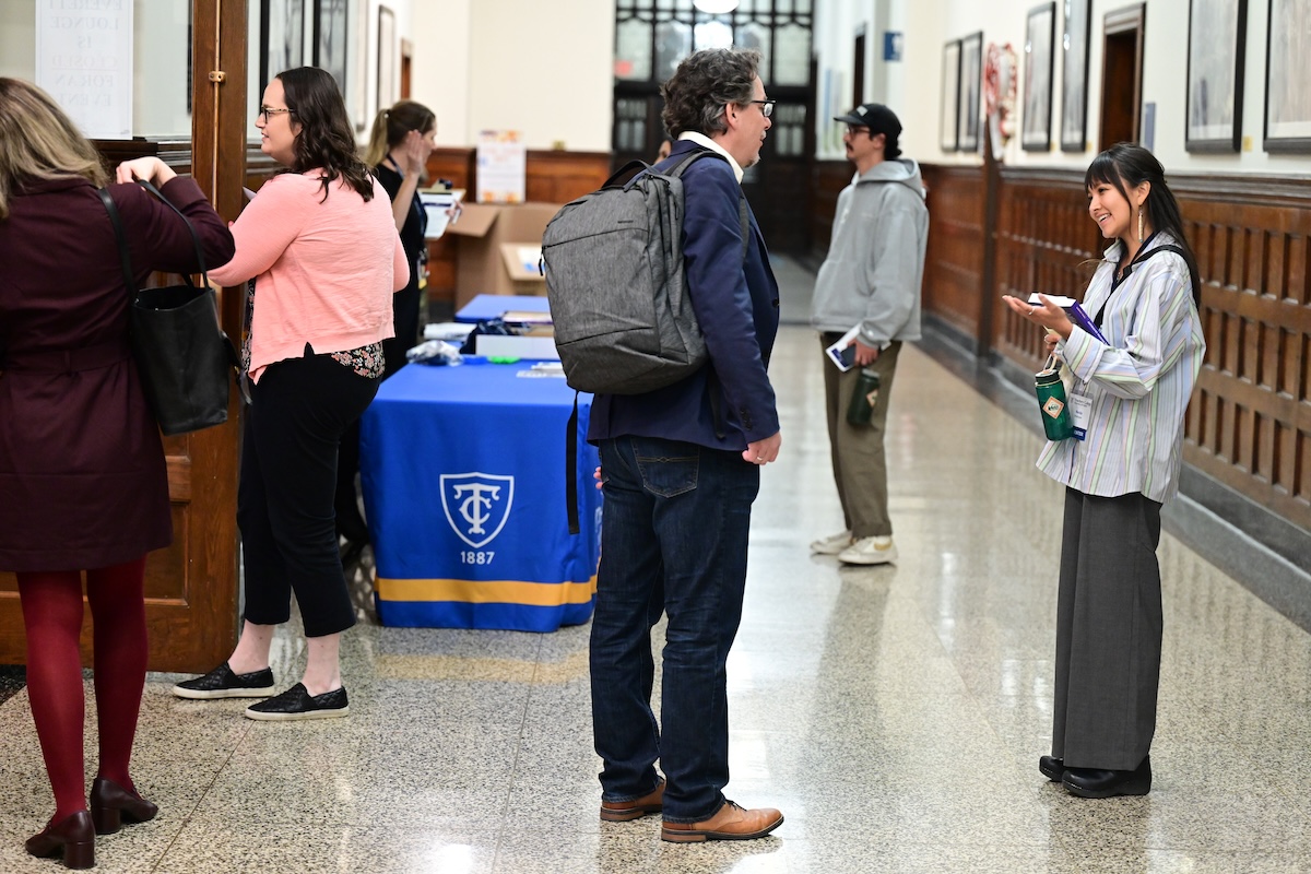 People milling in a hallway, chatting before a networking hour.