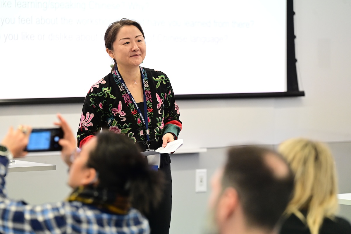 Xiaoyi Wei speaking to a room of people