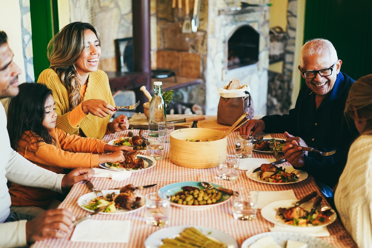 A happy latine family having fun eating together at home