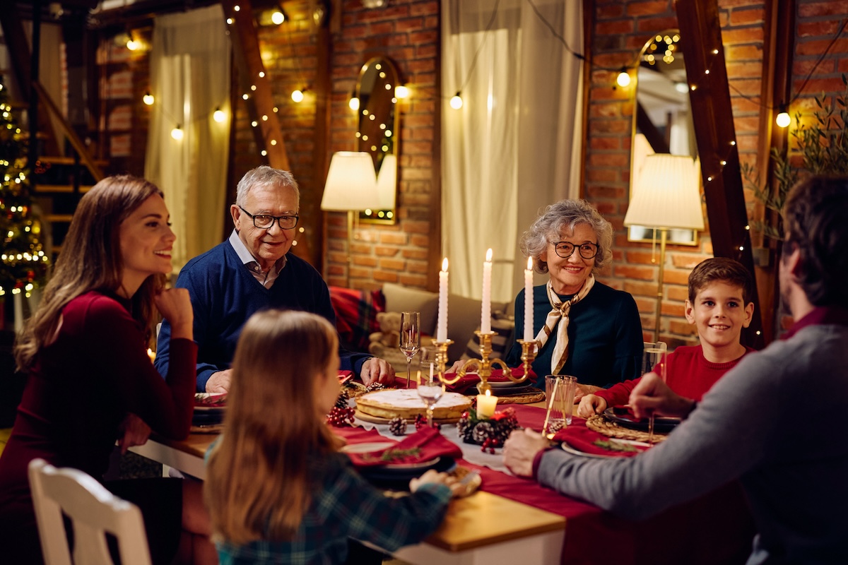 Happy multigenerational white family talking during Christmas dinner at dining table