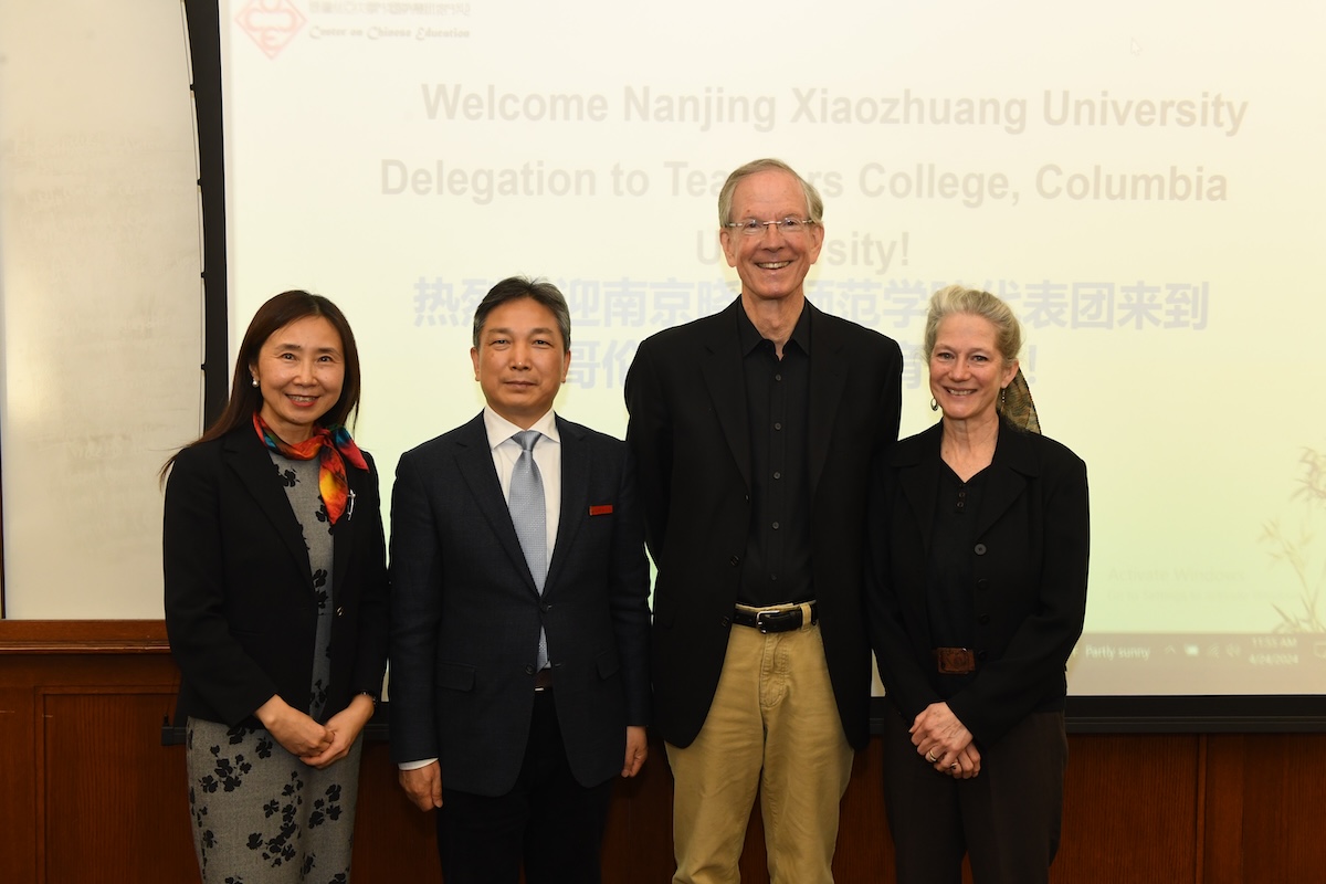 Four people ( a chinese woman, chinese man, white man and white woman) standing for a picture