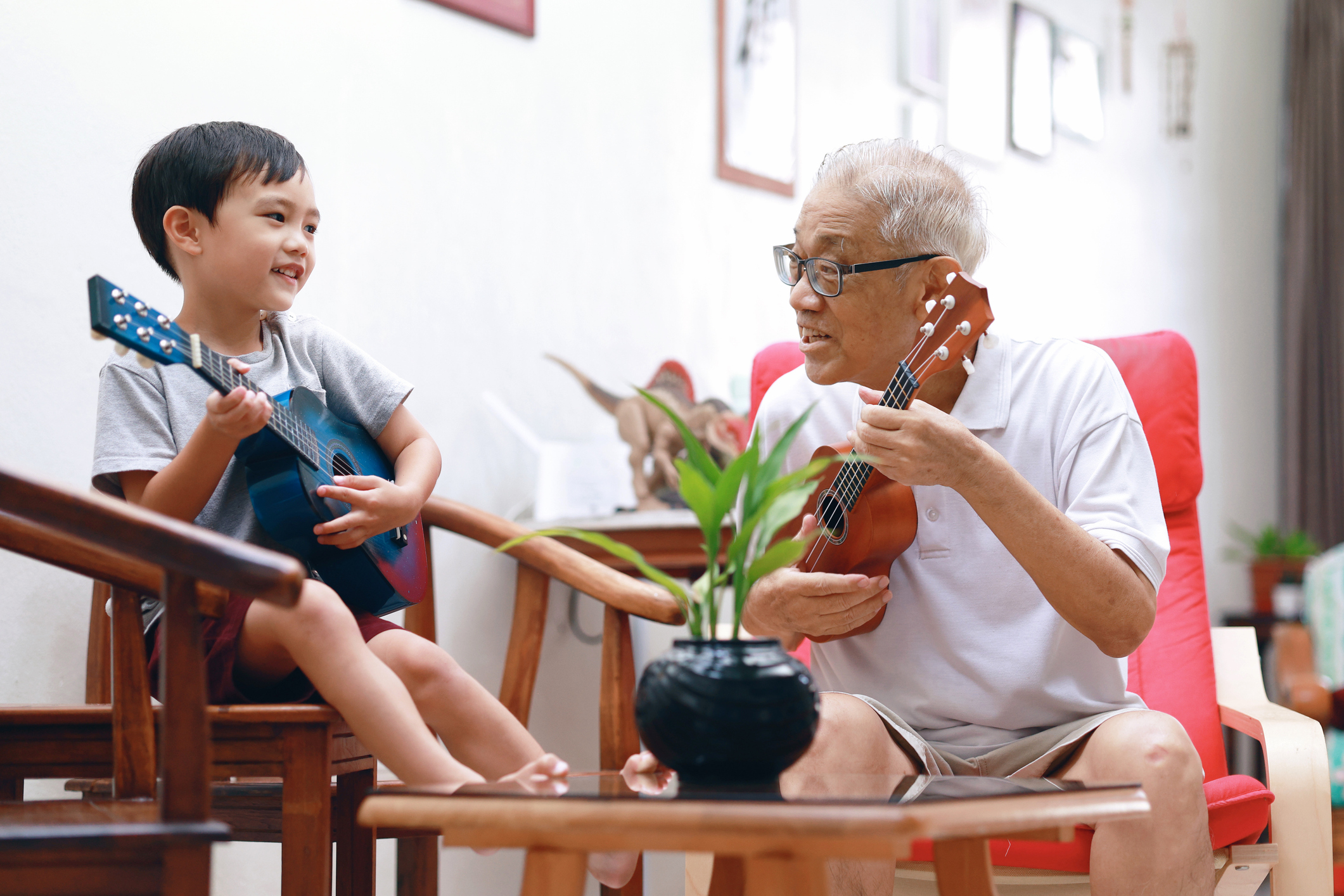 Child plays guitar with grandparent.