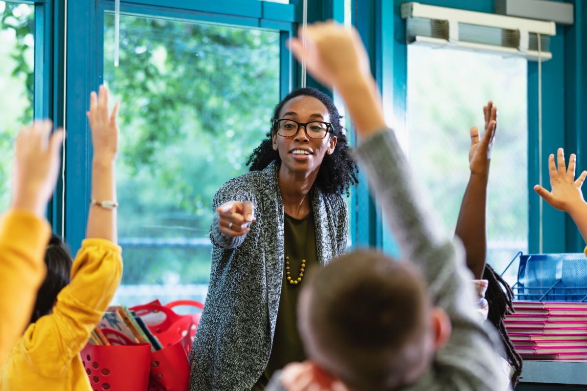 high five and teacher with children in classroom