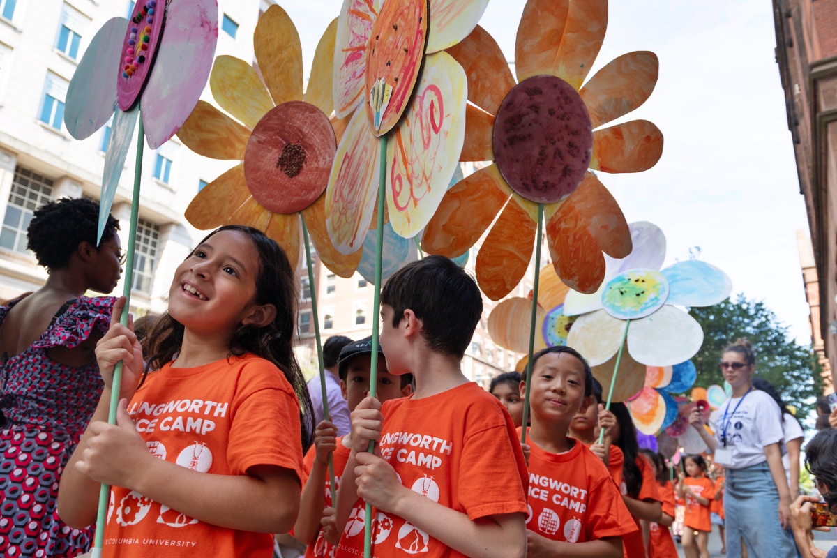 Children hold giant craft flowers as part of the Hollingworth Science Camp Parade.