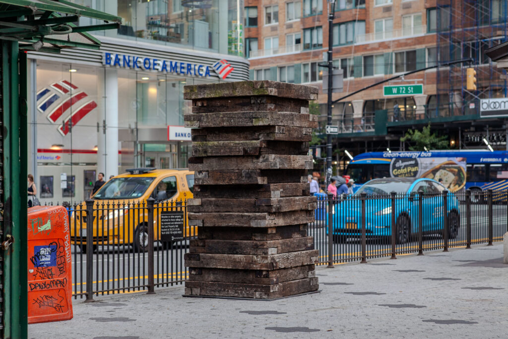 An outdoor sculpture consisting of 15 wooden square stacked on top of each other