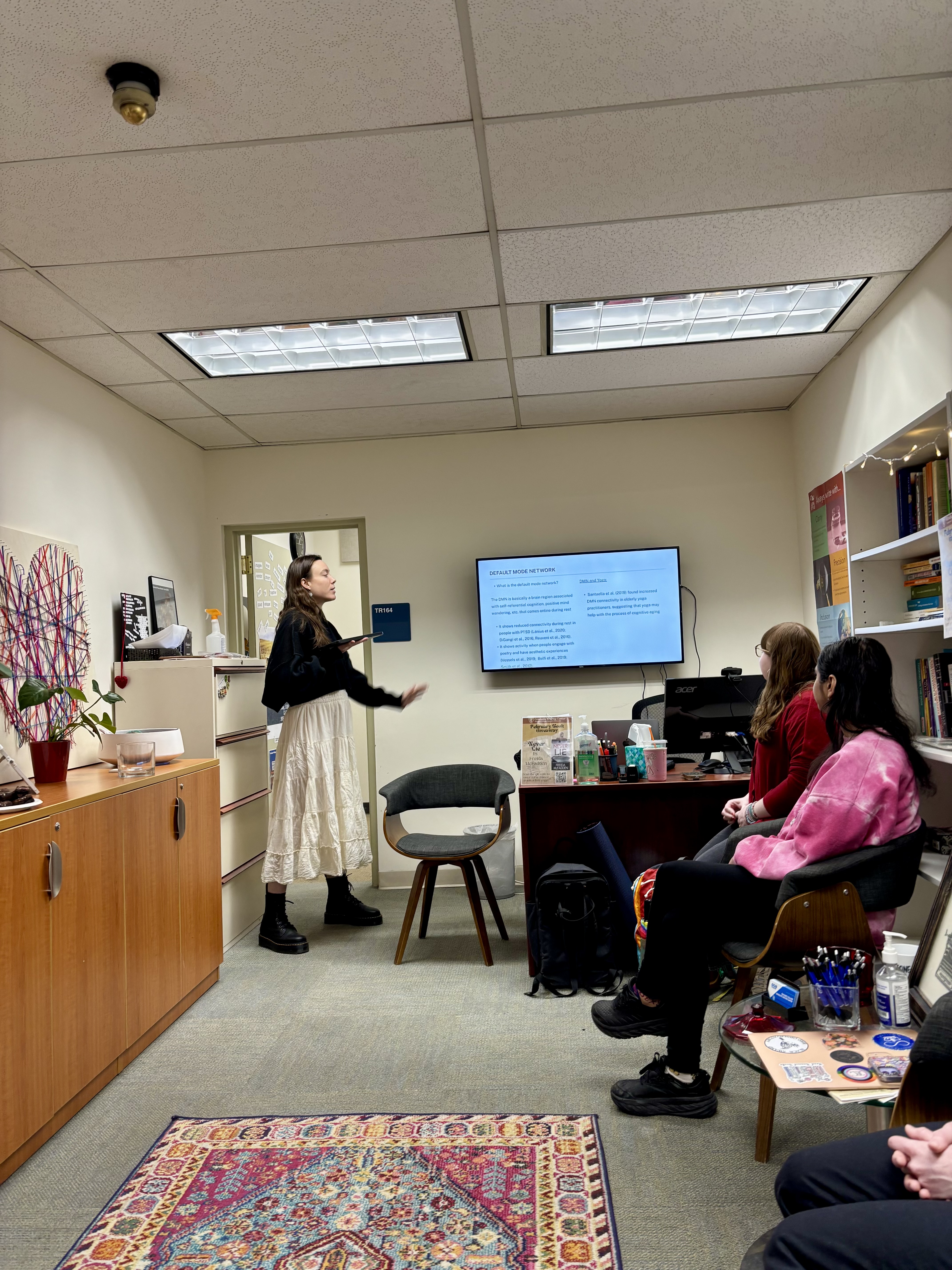 picture of Megan giving a presentation at the GWC staff meeting on stress reduction techniques for writers